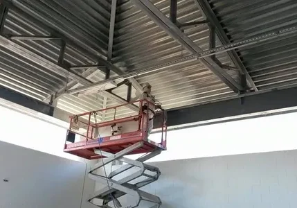 A man is on a scissor lift in the air.